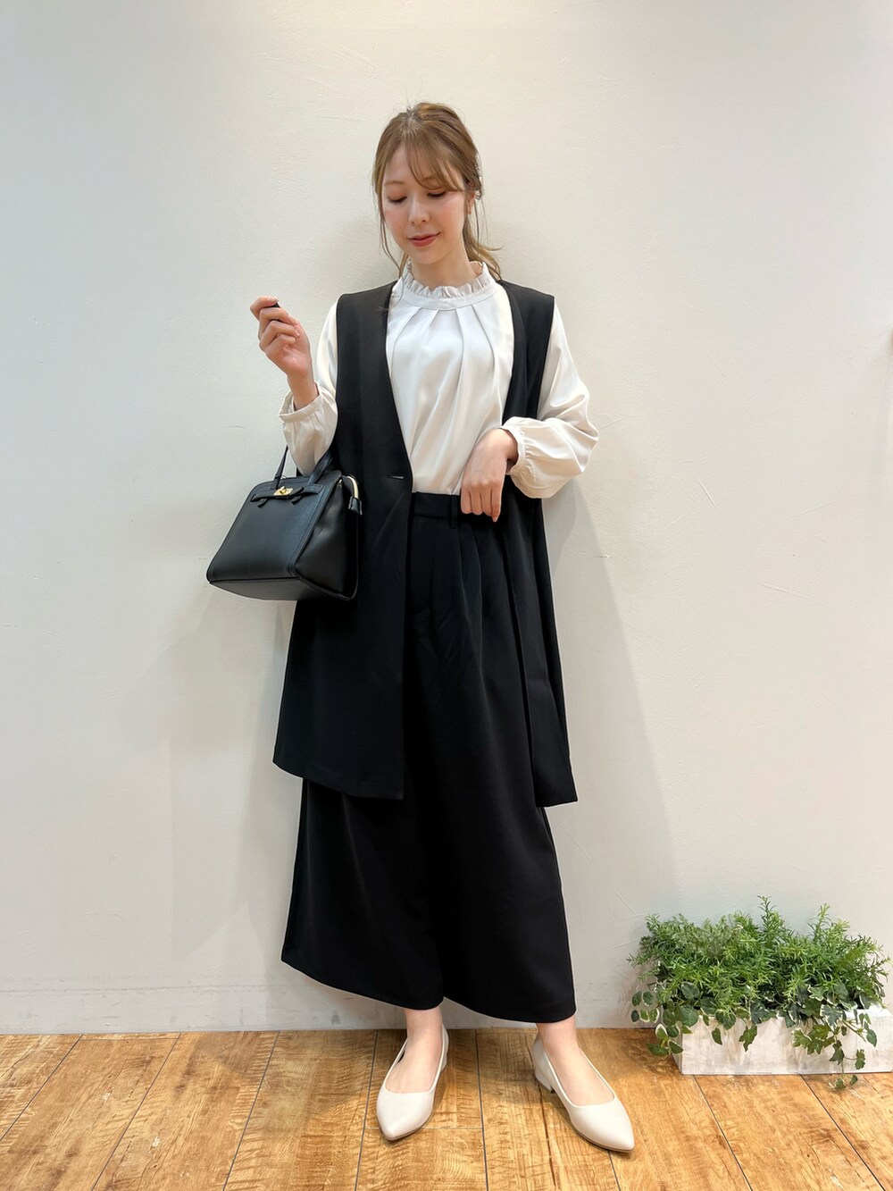 ブラック系のベスト、ベージュ系のシャツ/ブラウス、ブラック系のその他パンツを着用したレディースの冬コーディネートの2枚目の写真