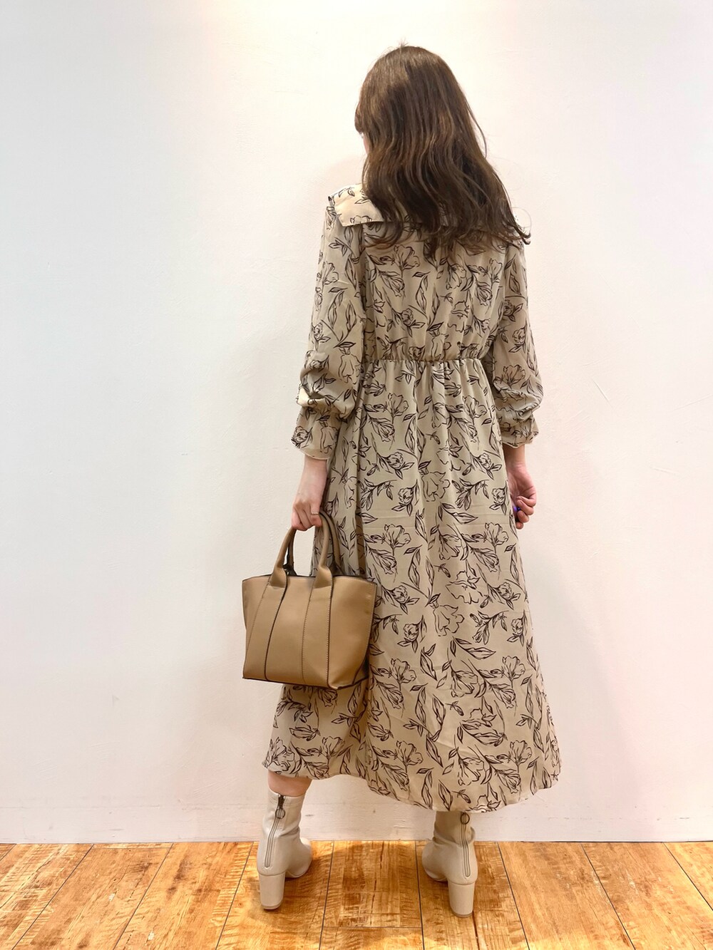 ベージュ系のワンピース、ブラック系のトートバッグ、ホワイト系のブーツを着用したレディースの秋コーディネートの3枚目の写真