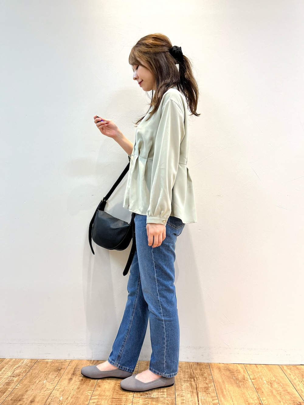 グリーン系のシャツ/ブラウス、ブルー系のデニムパンツ、ベージュ系のパンプスを着用したレディースの秋コーディネートの2枚目の写真