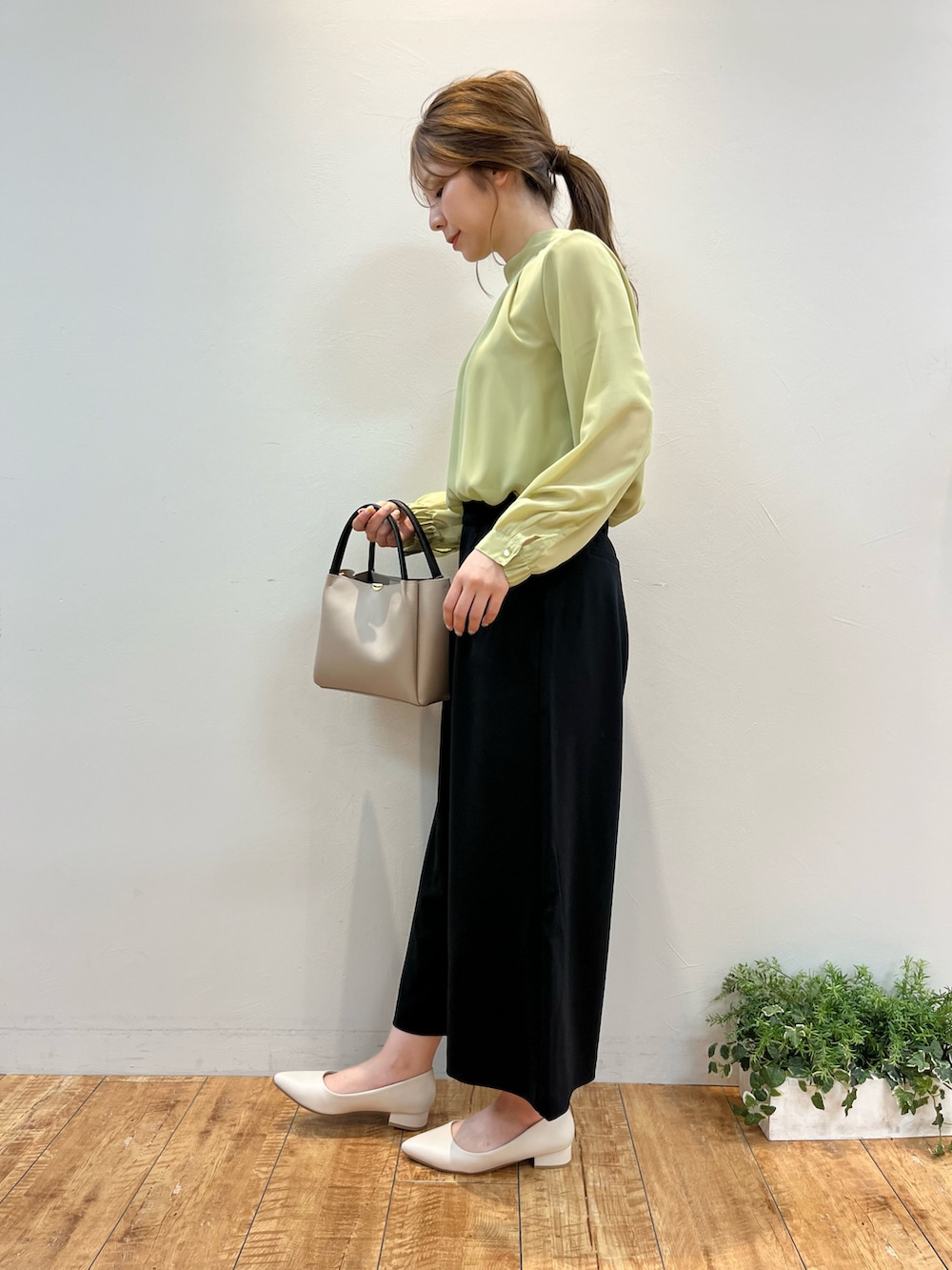 グリーン系のシャツ/ブラウス、ブラック系のその他パンツ、グレー系のトートバッグを着用したレディースの春コーディネートの2枚目の写真