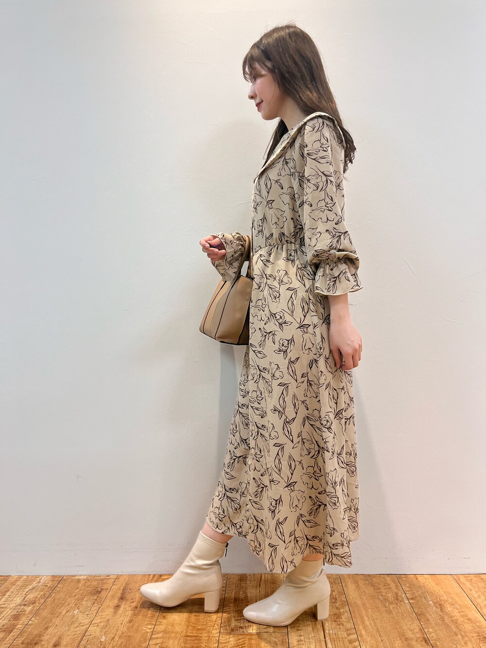 ベージュ系のワンピース、ブラック系のトートバッグ、ホワイト系のブーツを着用したレディースの秋コーディネートの2枚目の写真