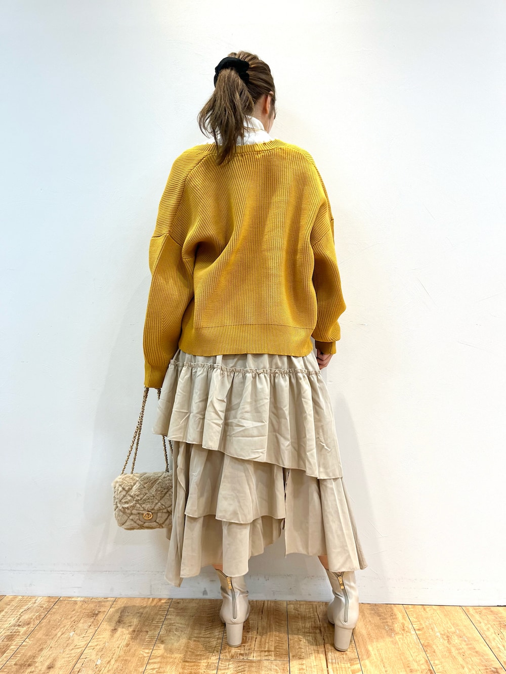 イエロー系のカーディガン/ボレロ、ホワイト系のTシャツ/カットソー、ベージュ系のスカートを着用したレディースの秋コーディネートの3枚目の写真