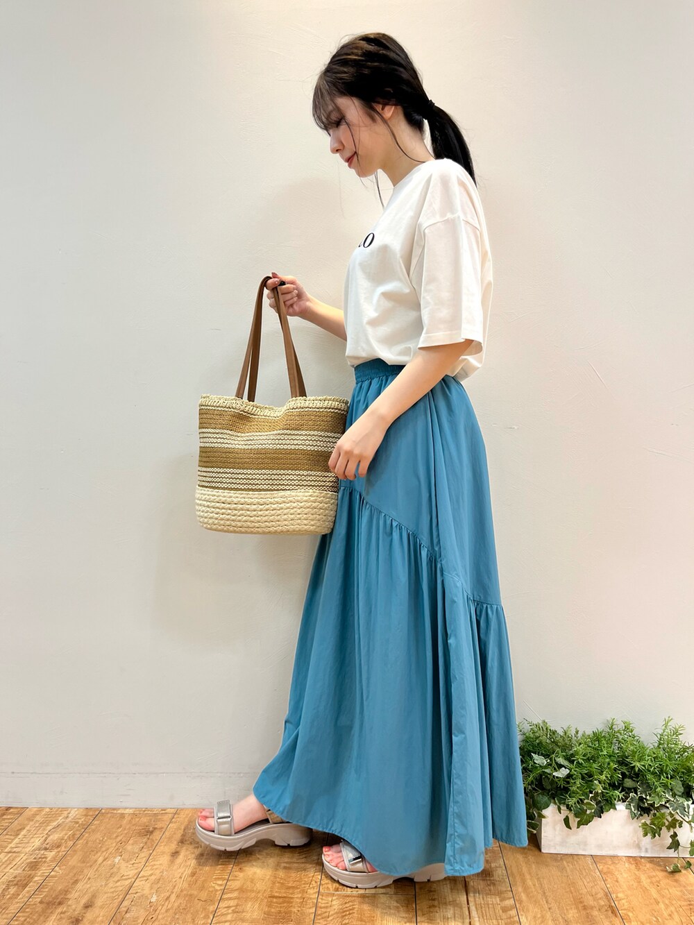 ホワイト系のTシャツ/カットソー、ブルー系のスカート、イエロー系のトートバッグを着用したレディースの夏コーディネートの2枚目の写真