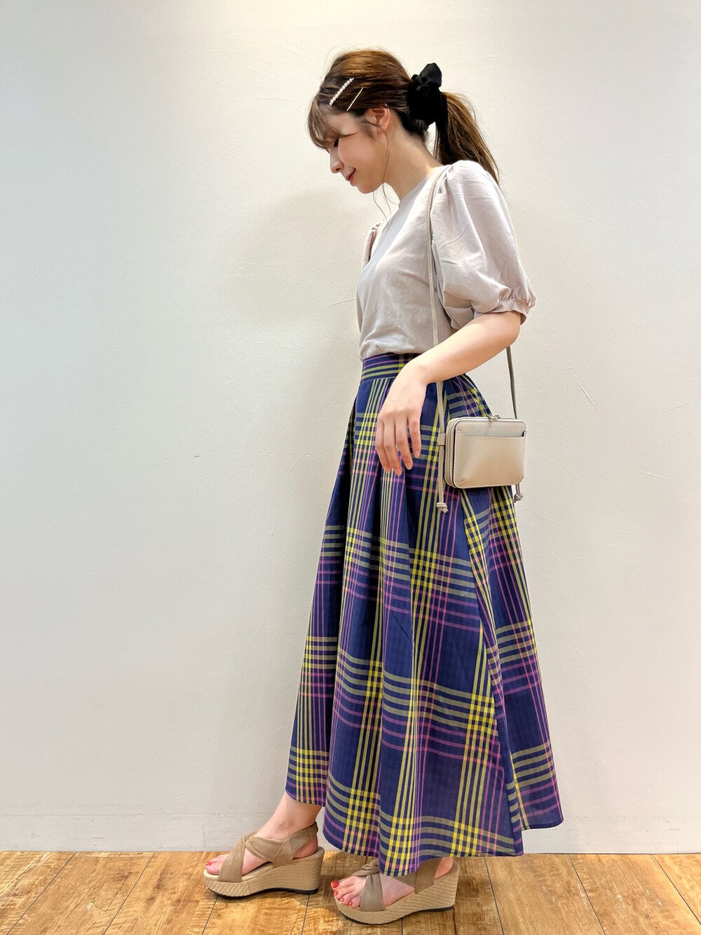 ベージュ系のTシャツ/カットソー、ブルー系のスカート、ベージュ系のサンダルを着用したレディースの夏コーディネートの2枚目の写真