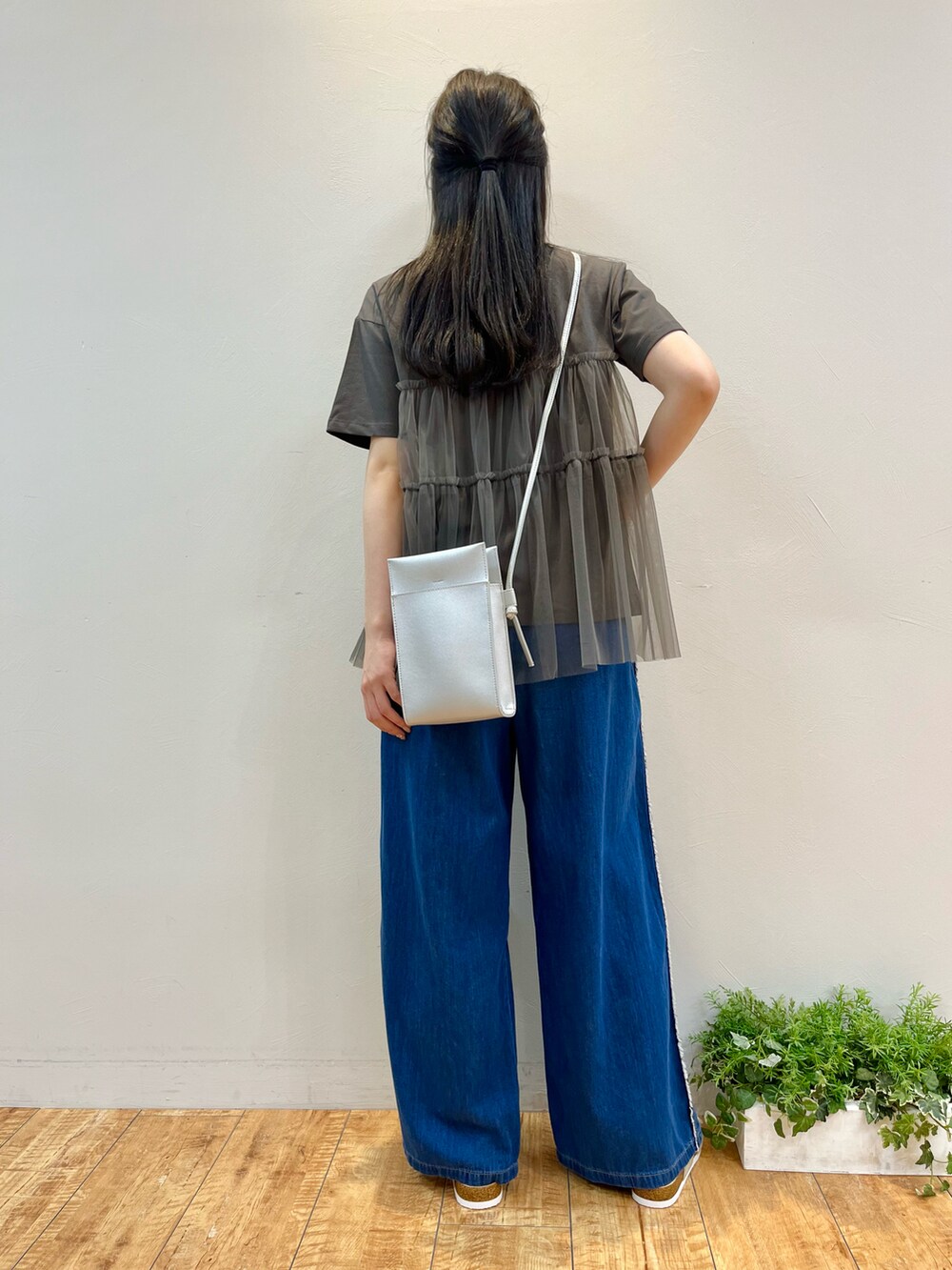 グレー系のTシャツ/カットソー、ブルー系のデニムパンツ、シルバー系のショルダーバッグを着用したレディースの夏コーディネートの3枚目の写真