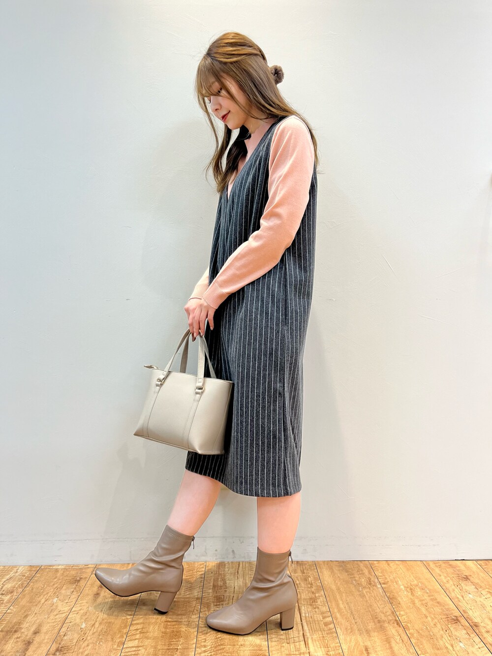 ブラック系のワンピース、ピンク系のニット/セーター、グレー系のトートバッグを着用したレディースの冬コーディネートの2枚目の写真