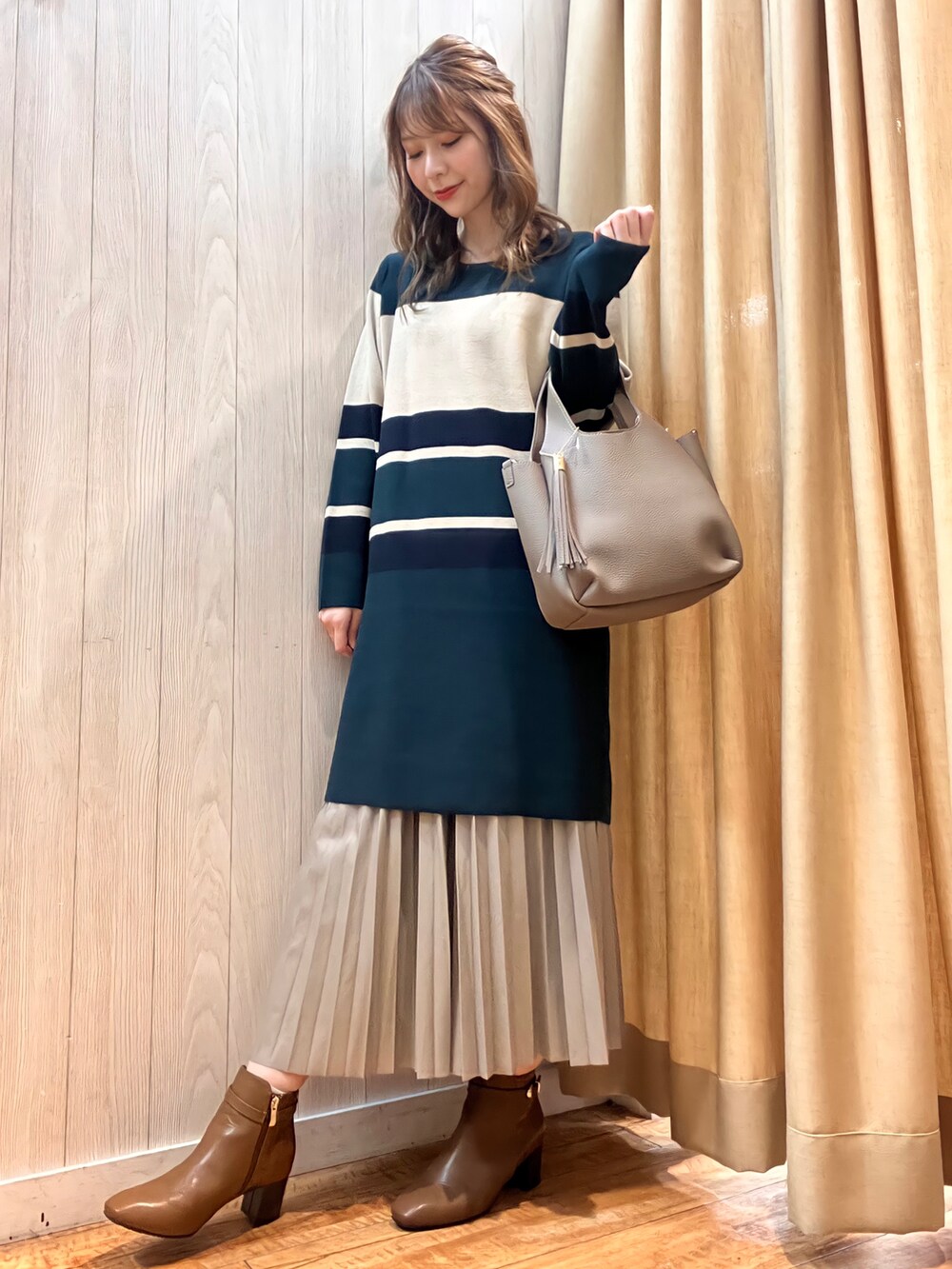 グリーン系のワンピース、グレー系のスカート、グレー系のトートバッグを着用したレディースの秋コーディネートの2枚目の写真