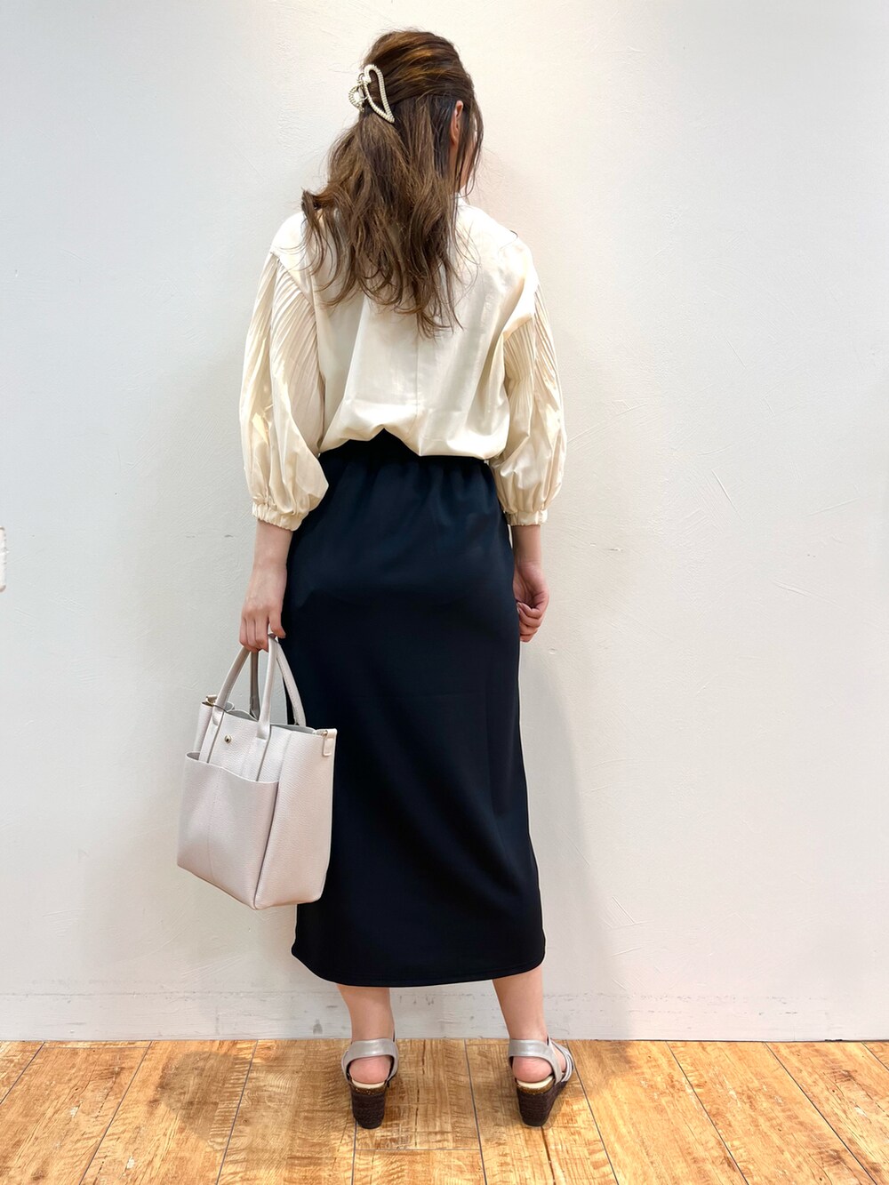 ベージュ系のシャツ/ブラウス、ブルー系のスカート、グレー系のトートバッグを着用したレディースの春コーディネートの3枚目の写真