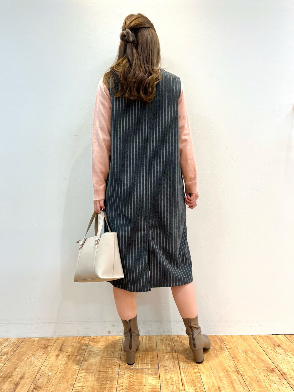 ブラック系のワンピース、ピンク系のニット/セーター、グレー系のトートバッグを着用したレディースの冬コーディネートの3枚目の写真