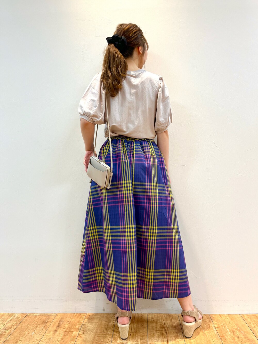 ベージュ系のTシャツ/カットソー、ブルー系のスカート、ベージュ系のサンダルを着用したレディースの夏コーディネートの3枚目の写真