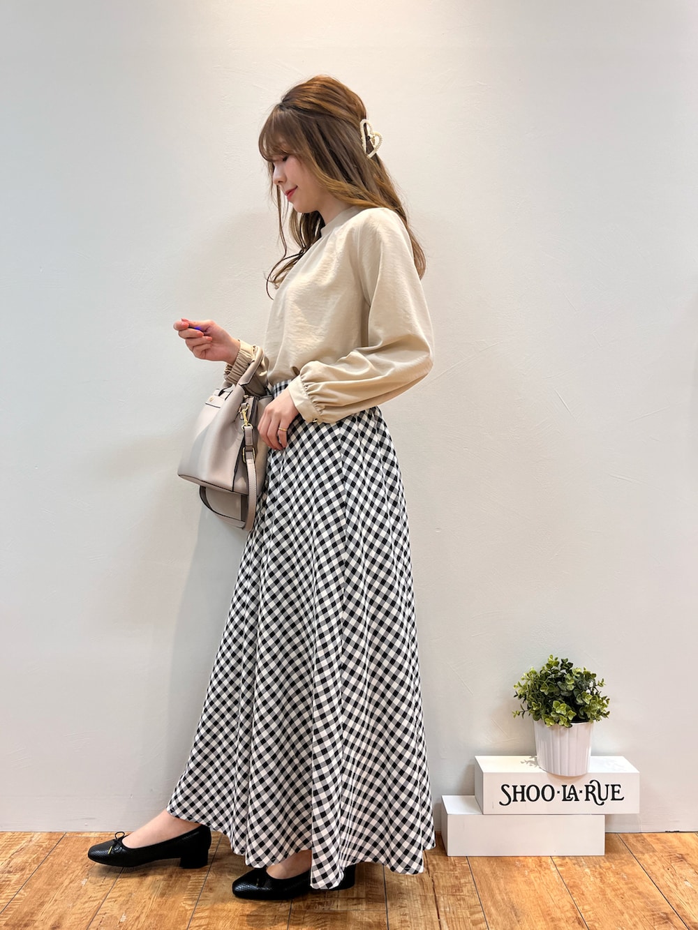 ベージュ系のシャツ/ブラウス、グレー系のトートバッグ、ブラック系のスカートを着用したレディースの春コーディネートの2枚目の写真