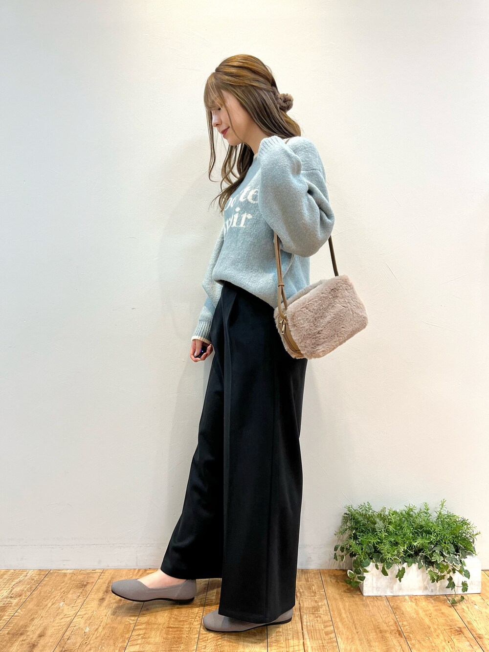 グリーン系のニット/セーター、ブラック系のその他パンツ、ブラウン系のショルダーバッグを着用したレディースの冬コーディネートの2枚目の写真