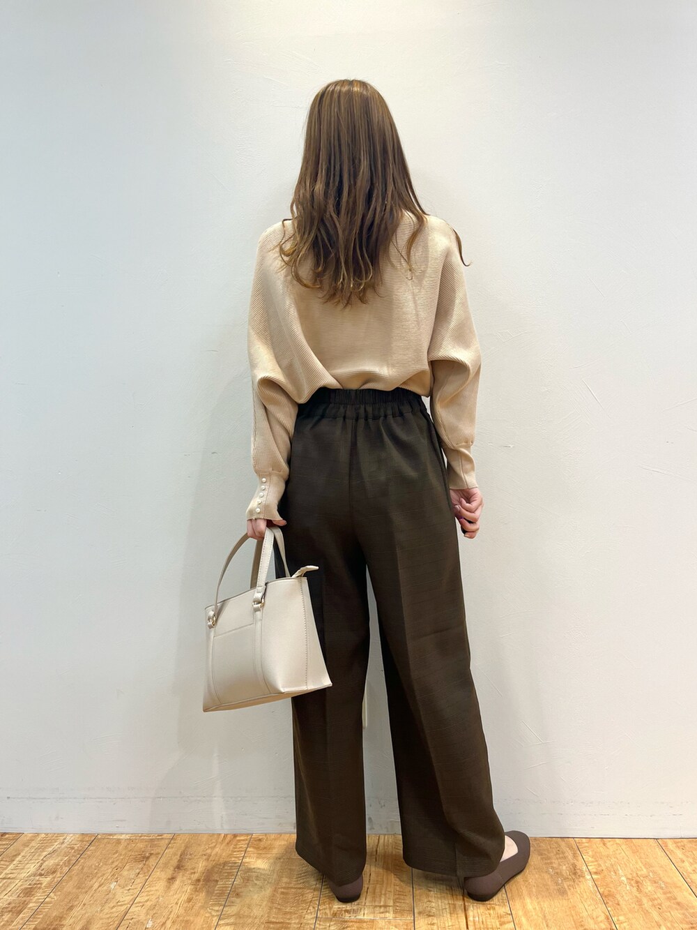 ベージュ系のニット/セーター、ブラウン系のその他パンツ、グレー系のトートバッグを着用したレディースの冬コーディネートの3枚目の写真