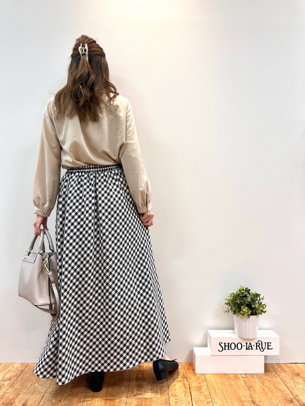 ベージュ系のシャツ/ブラウス、グレー系のトートバッグ、ブラック系のスカートを着用したレディースの春コーディネートの3枚目の写真