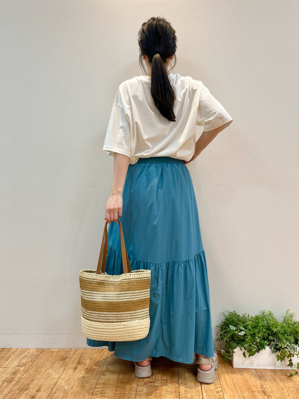 ホワイト系のTシャツ/カットソー、ブルー系のスカート、イエロー系のトートバッグを着用したレディースの夏コーディネートの3枚目の写真