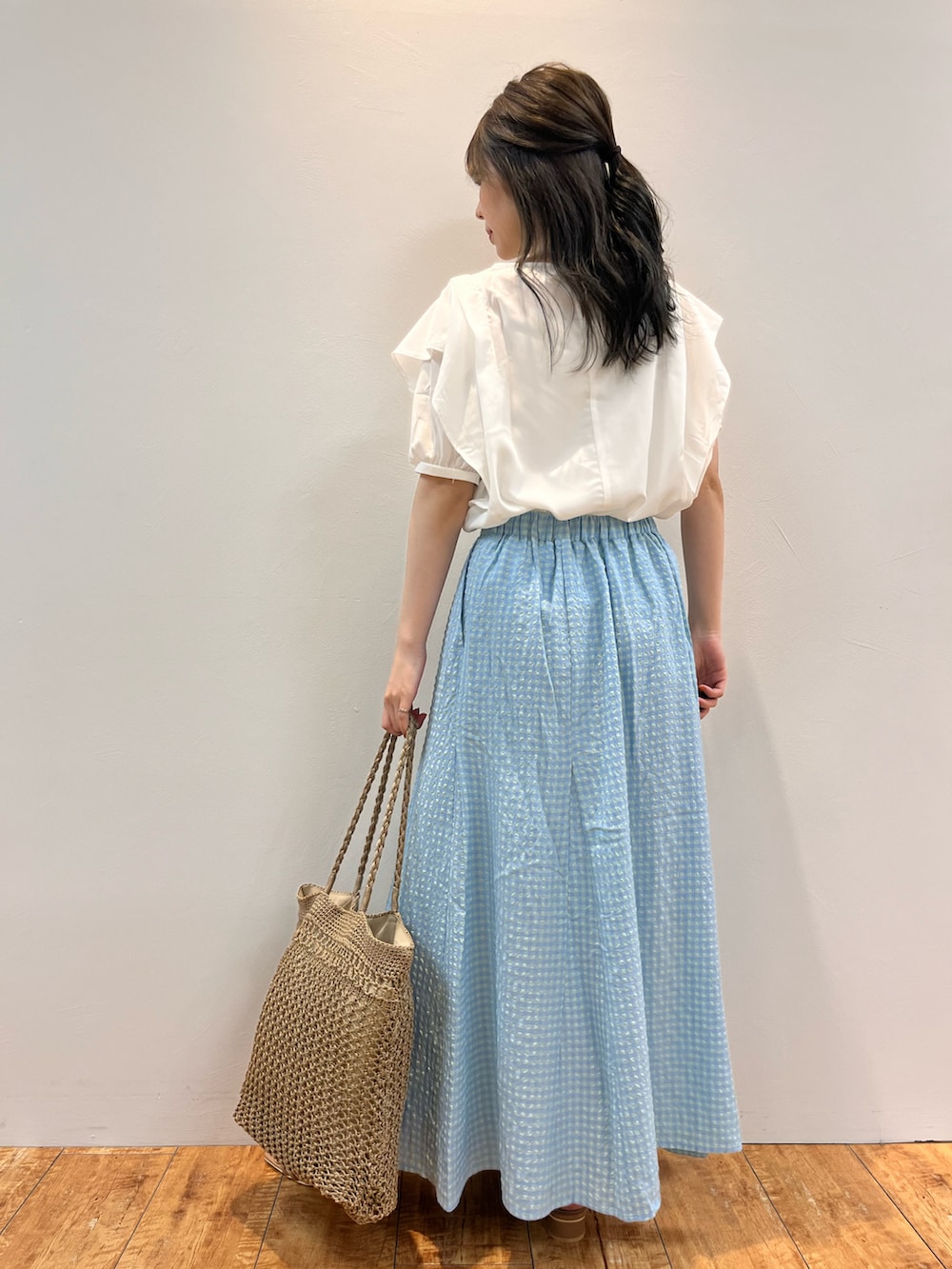ホワイト系のシャツ/ブラウス、ブルー系のスカート、ベージュ系のトートバッグを着用したレディースの夏コーディネートの3枚目の写真
