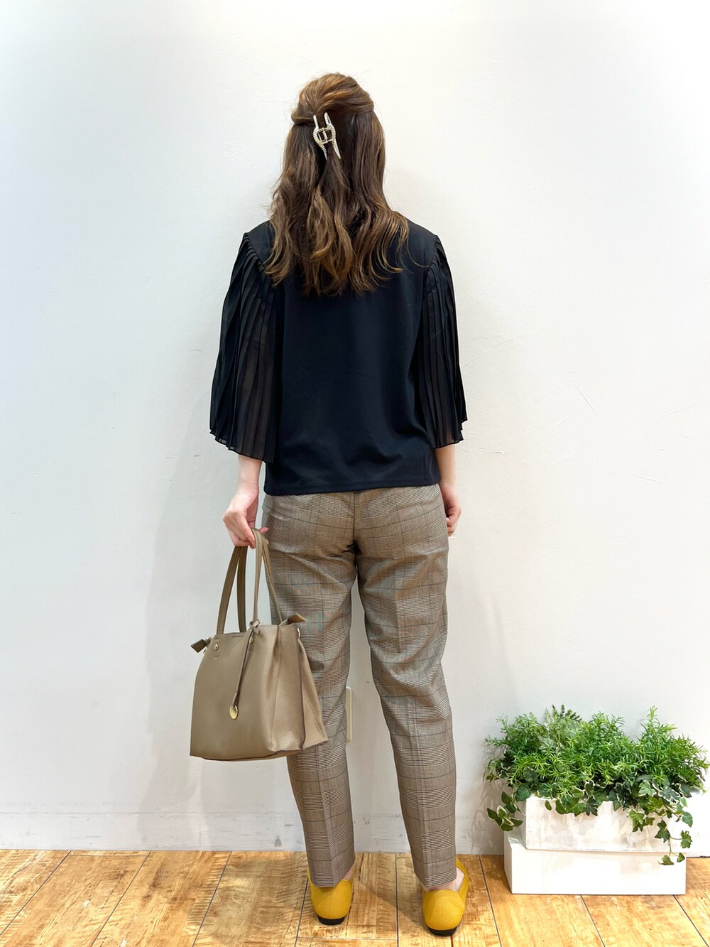 ブラック系のTシャツ/カットソー、ブラウン系のその他パンツ、イエロー系のパンプスを着用したレディースの秋コーディネートの3枚目の写真