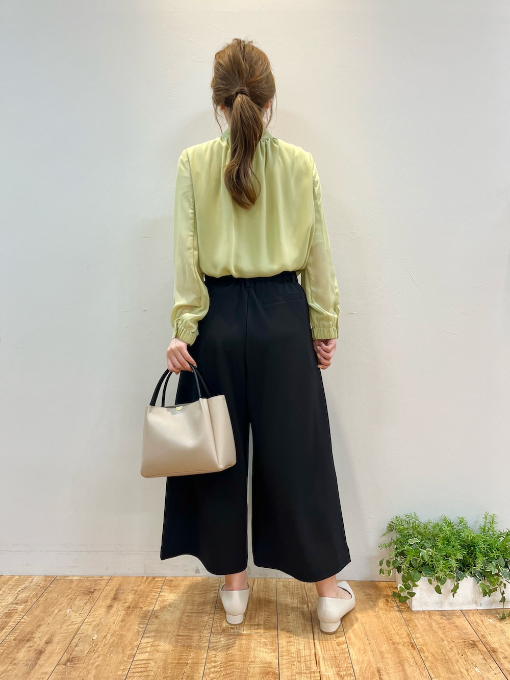 グリーン系のシャツ/ブラウス、ブラック系のその他パンツ、グレー系のトートバッグを着用したレディースの春コーディネートの3枚目の写真