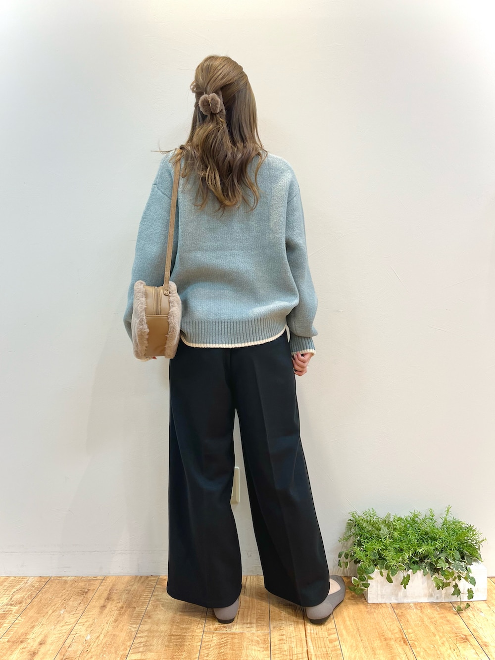 グリーン系のニット/セーター、ブラック系のその他パンツ、ブラウン系のショルダーバッグを着用したレディースの冬コーディネートの3枚目の写真