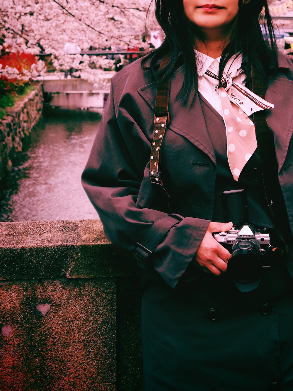 ブラウン系のトレンチコート、ブラウン系のワンピース、ホワイト系のシャツワンピースを着用したレディースの春コーディネートの3枚目の写真