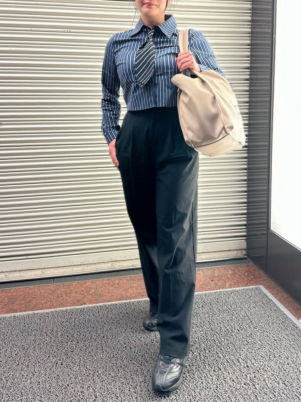 ブルー系のシャツ/ブラウス、ブラック系のパンツ、ベージュ系のトートバッグを着用したレディースの秋コーディネートの3枚目の写真