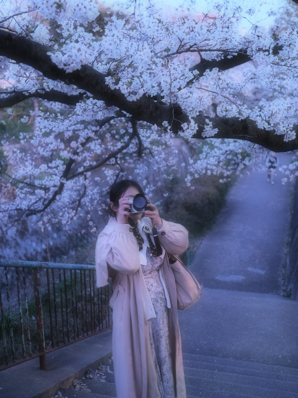 グレー系のワンピース、ホワイト系のカーディガン/ボレロ、ベージュ系のその他アウターを着用したレディースの春コーディネートの2枚目の写真