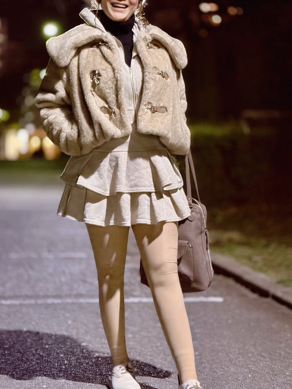 ベージュ系のその他アウター、ブラック系のニット/セーター、ホワイト系のスカートを着用したレディースの春コーディネートの2枚目の写真