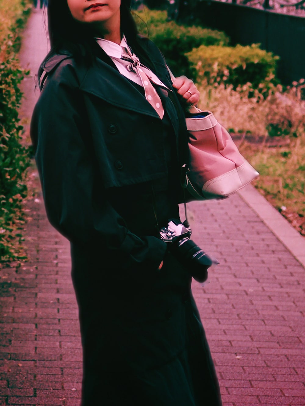 ブラウン系のトレンチコート、ブラウン系のワンピース、ホワイト系のシャツワンピースを着用したレディースの春コーディネートの2枚目の写真