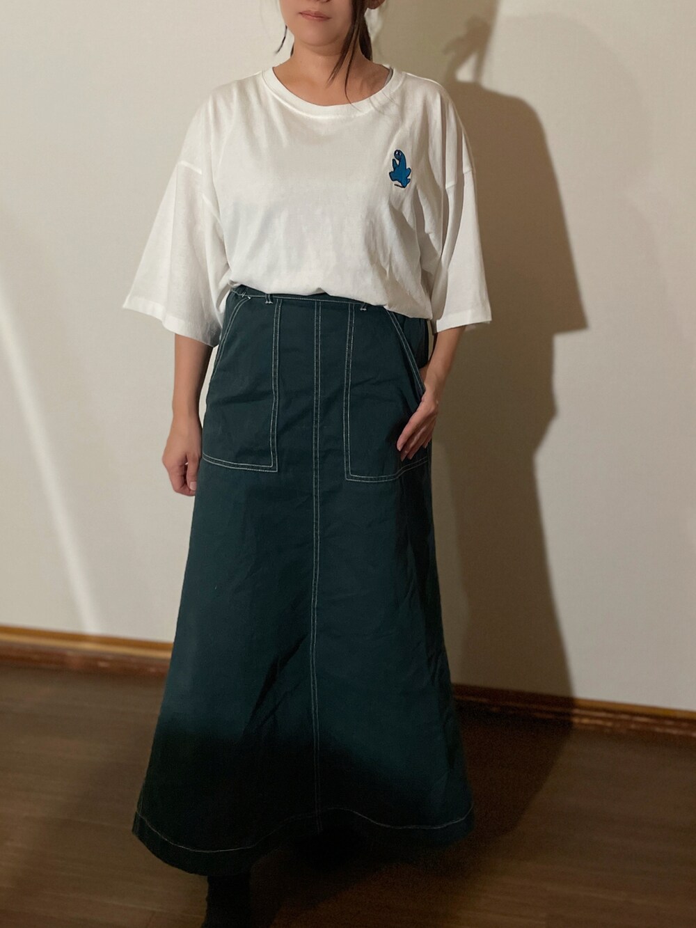 グリーン系のスカート、ホワイト系のTシャツ/カットソーを着用したレディースの夏コーディネートの2枚目の写真