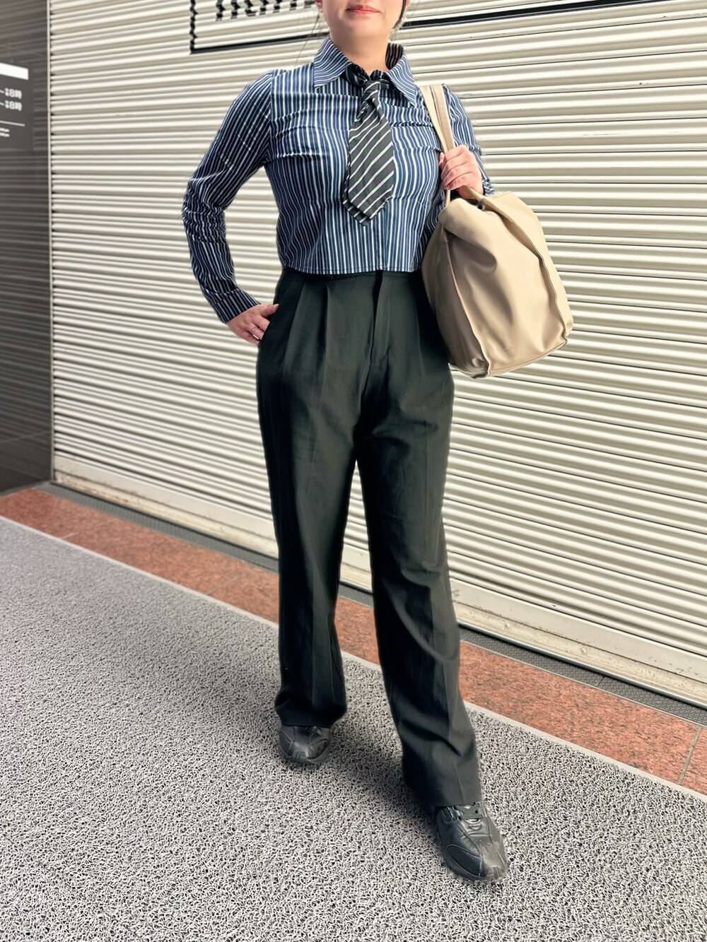 ブルー系のシャツ/ブラウス、ブラック系のパンツ、ベージュ系のトートバッグを着用したレディースの秋コーディネートの2枚目の写真