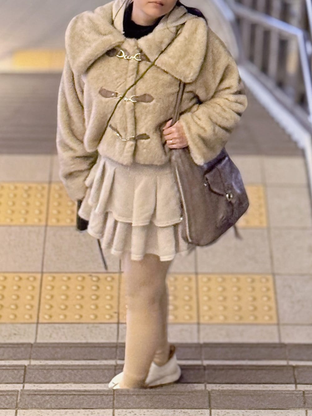 ベージュ系のその他アウター、ブラック系のニット/セーター、ホワイト系のスカートを着用したレディースの春コーディネートの3枚目の写真