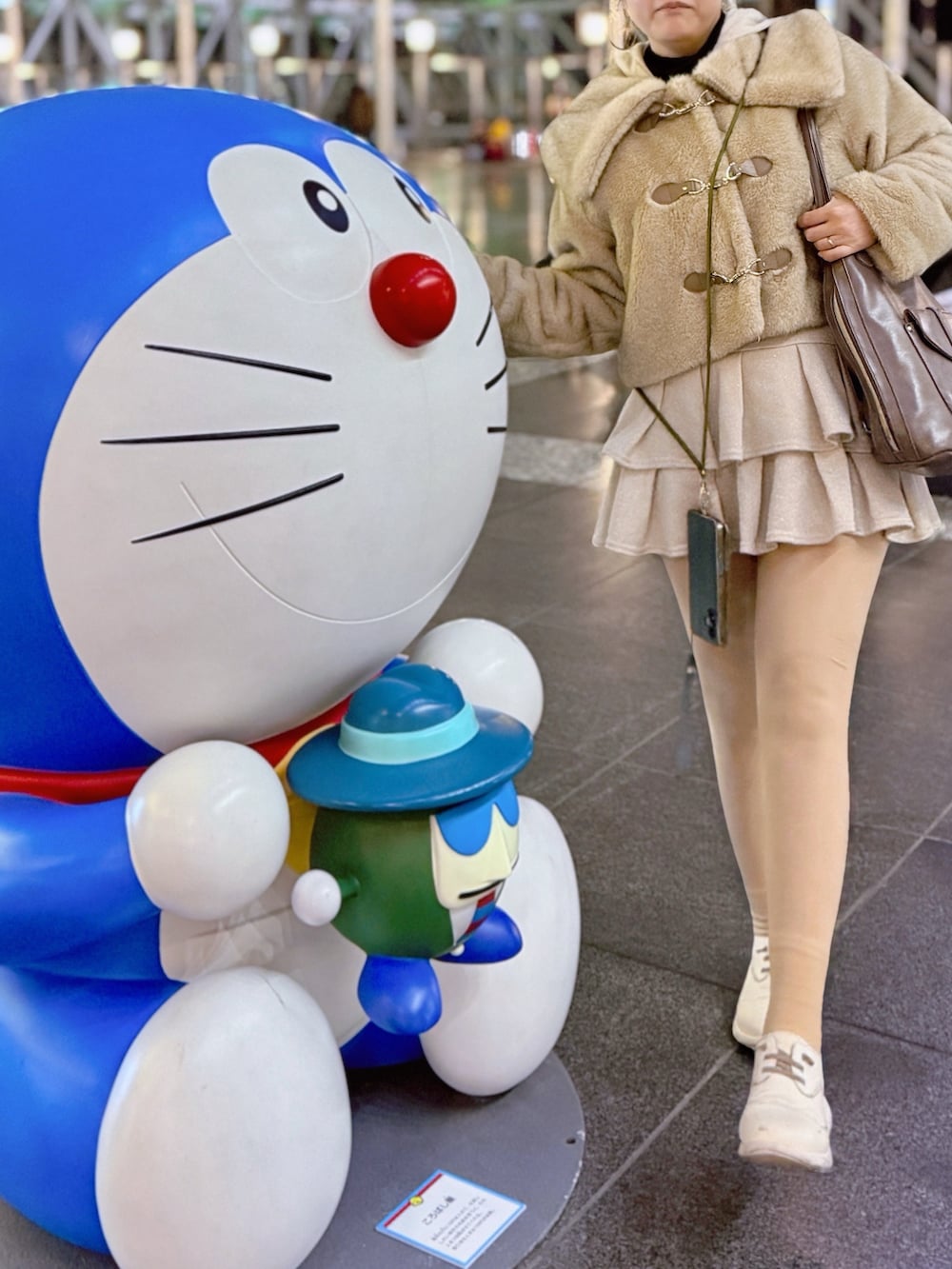 ベージュ系のその他アウター、ブラック系のニット/セーター、ホワイト系のスカートを着用したレディースの春コーディネートの4枚目の写真