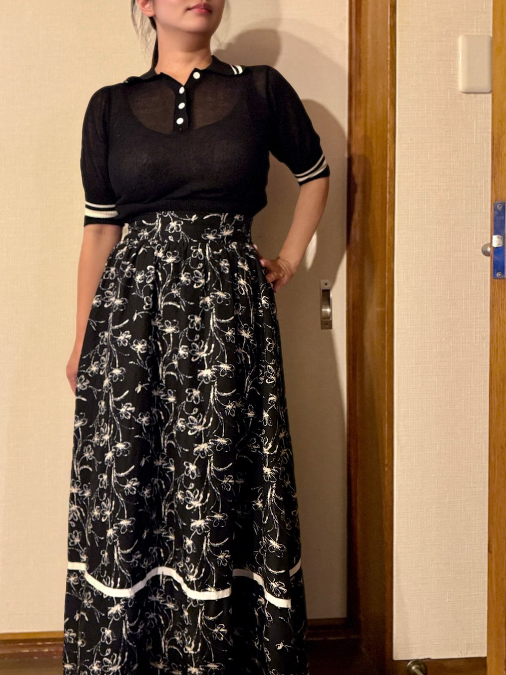 ブラック系のポロシャツ、ブラック系のスカートを着用したレディースの夏コーディネートの2枚目の写真