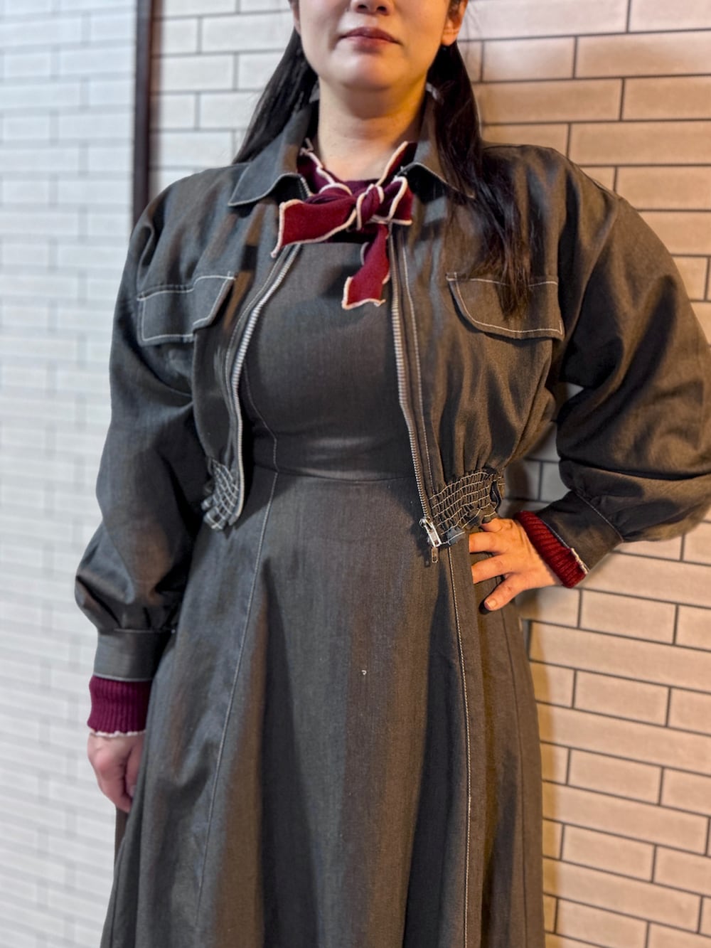 グレー系のワンピース/ドレス、レッド系のニット/セーターを着用したレディースの冬コーディネートの2枚目の写真