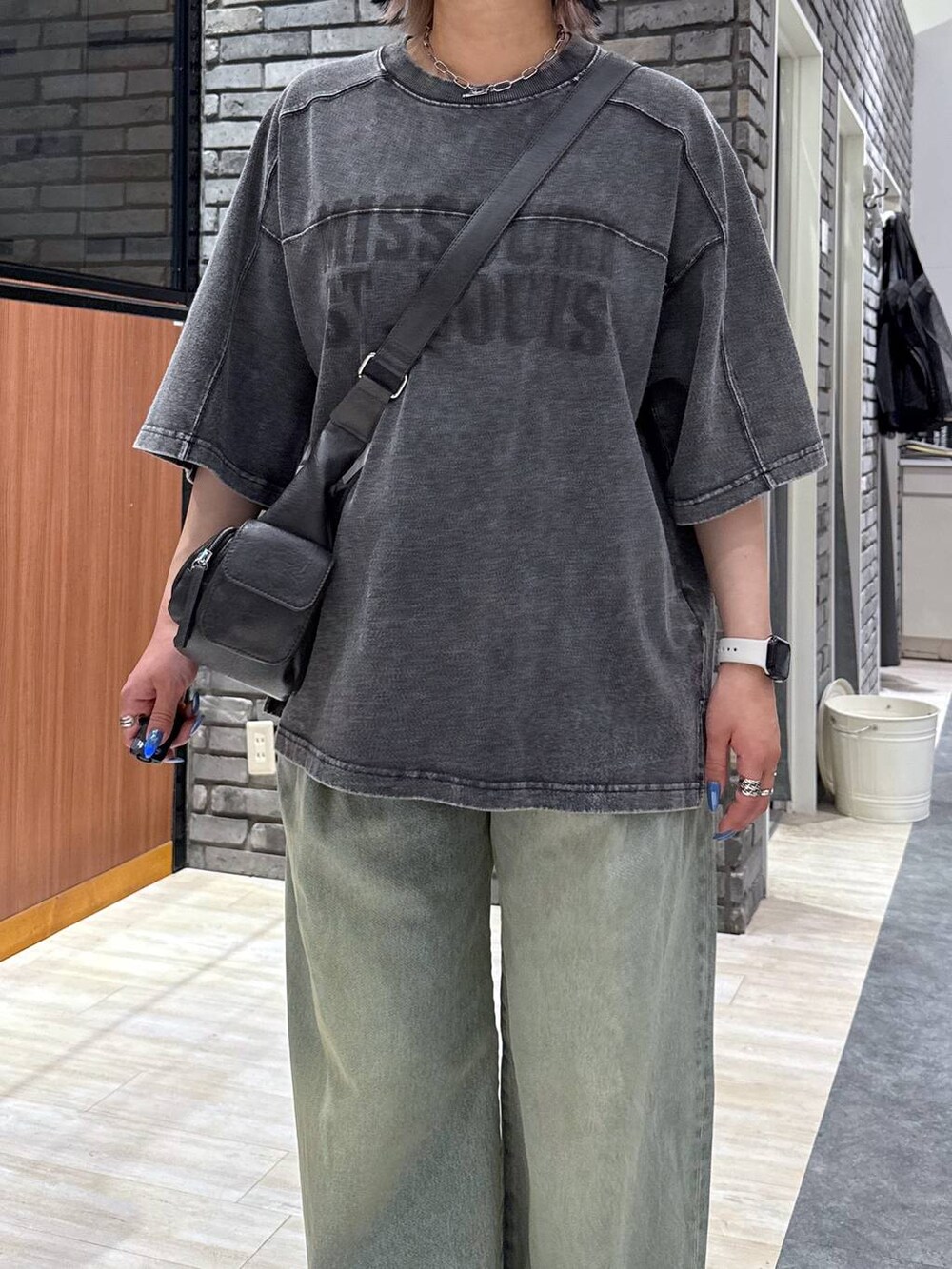 ブルー系のデニムパンツ、ブラック系のサンダル、ブラック系のTシャツ/カットソーを着用したレディースの春コーディネートの5枚目の写真