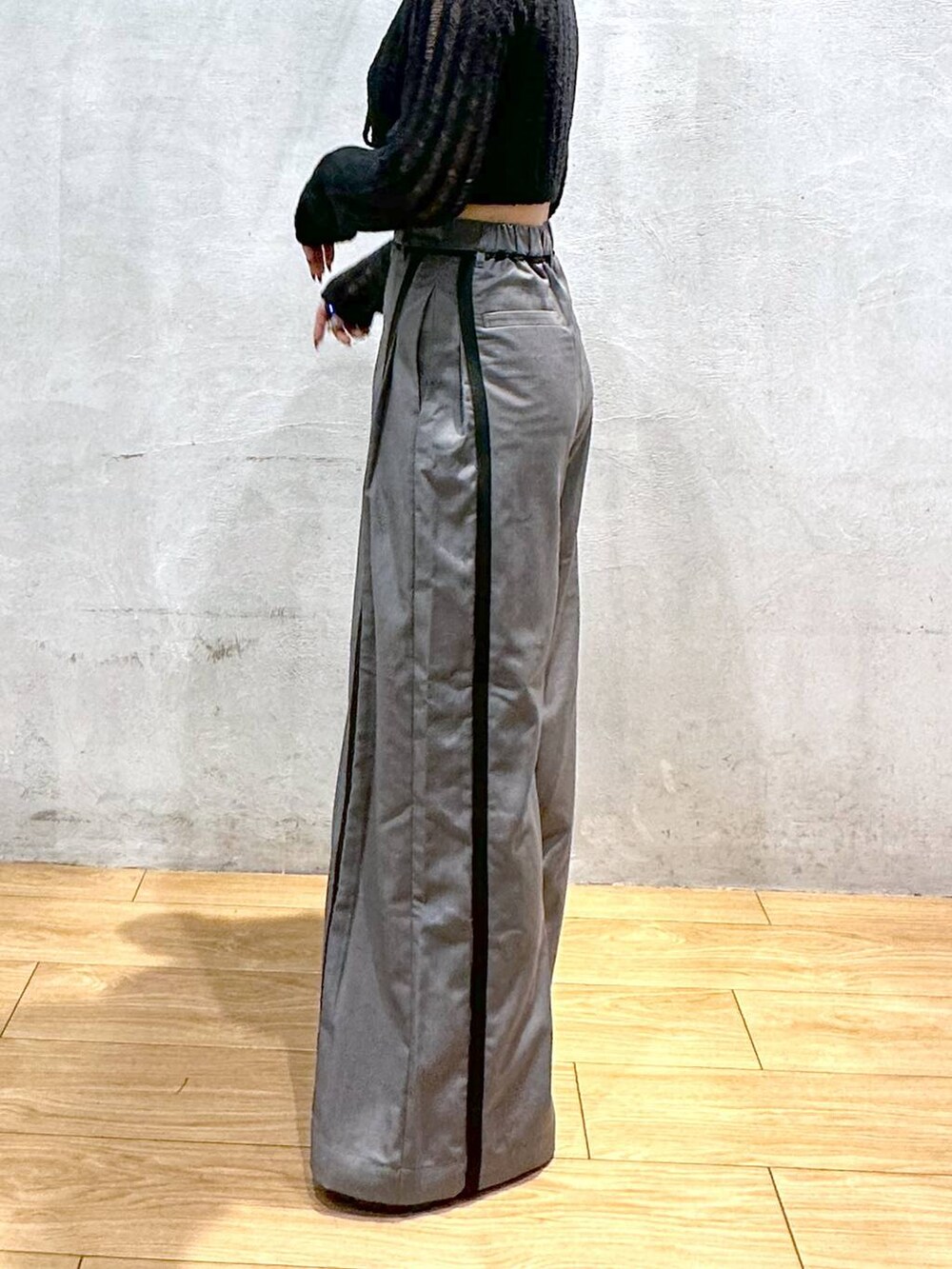 グレー系のスラックス、ブラック系のカーディガン/ボレロ、シルバー系のネックレスを着用したレディースの秋コーディネートの3枚目の写真