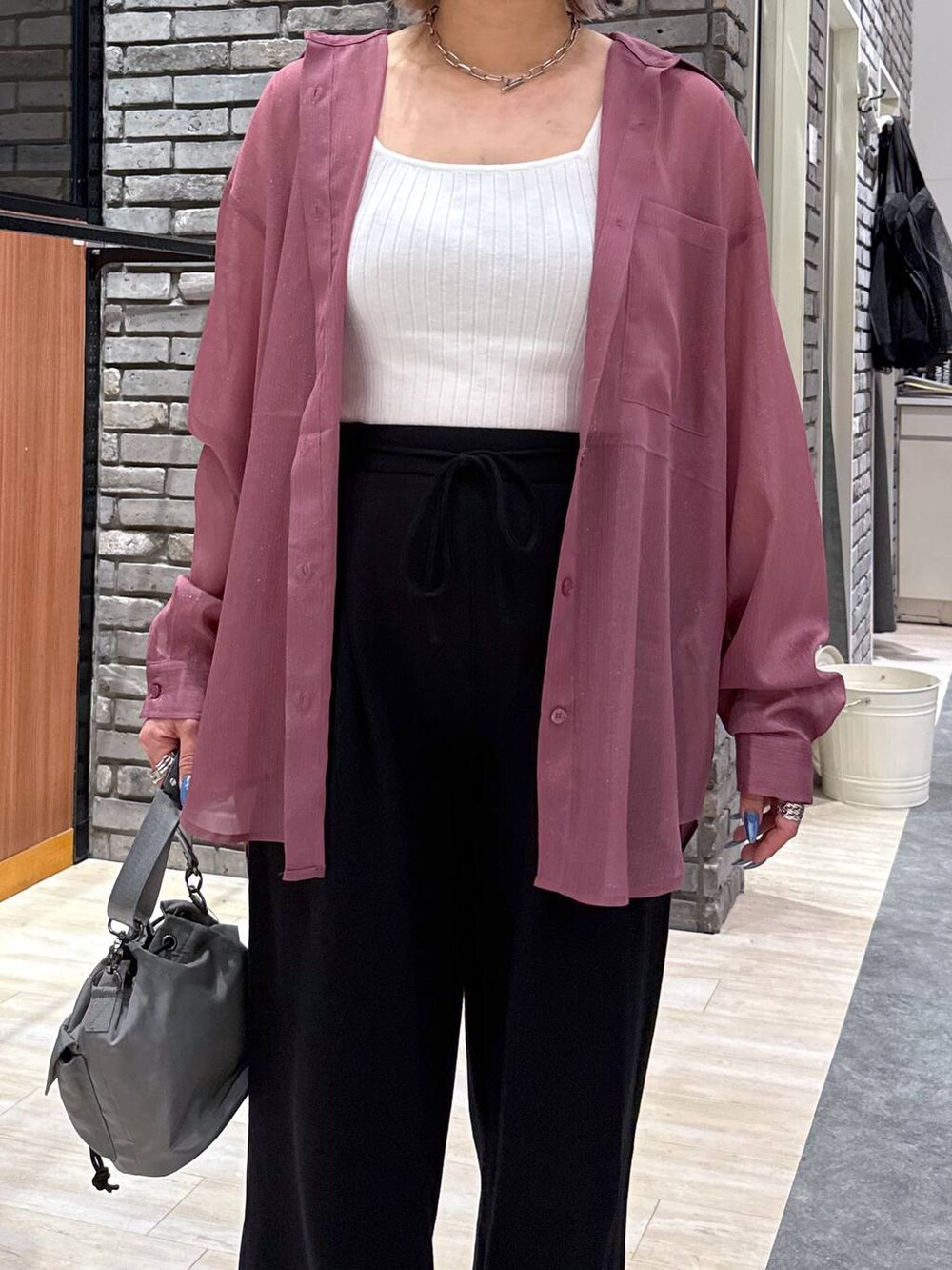 ベージュ系のショルダーバッグ、レッド系のシャツ/ブラウス、ブラック系のスウェットパンツを着用したレディースの春コーディネートの3枚目の写真