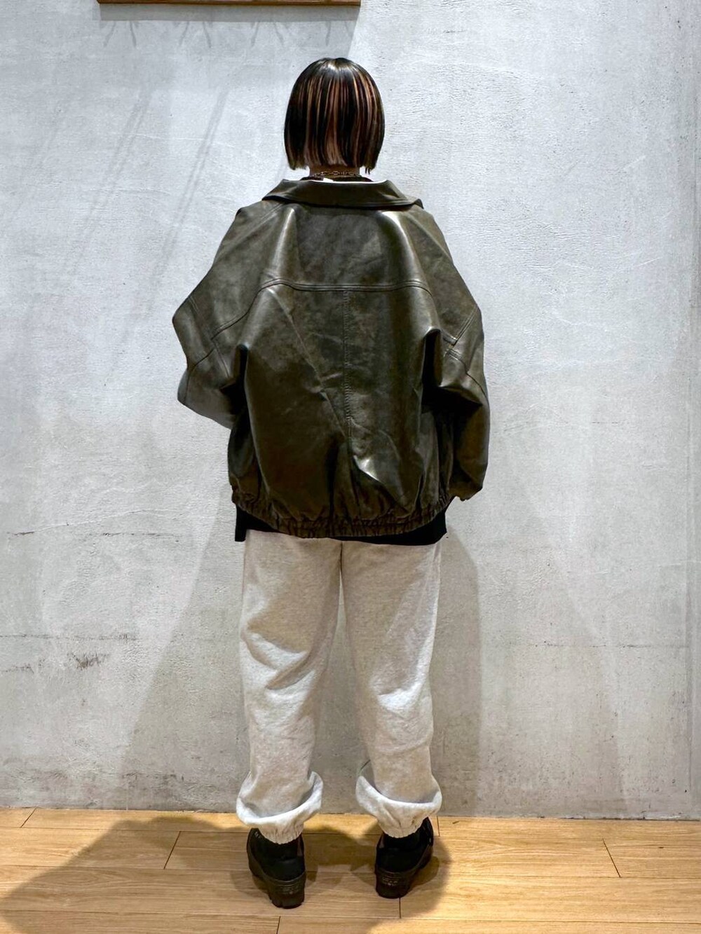 ブラウン系のブルゾン、グレー系のスウェットパンツ、ブラック系のニット/セーターを着用したレディースの秋コーディネートの4枚目の写真