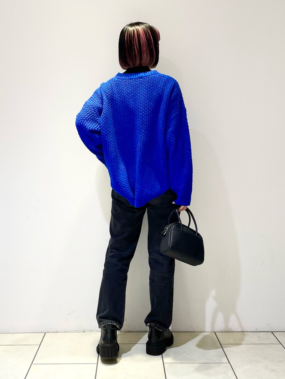 ブラック系のニット/セーター、ブルー系のニット/セーター、ブラック系のボストンバッグを着用したレディースの春コーディネートの4枚目の写真