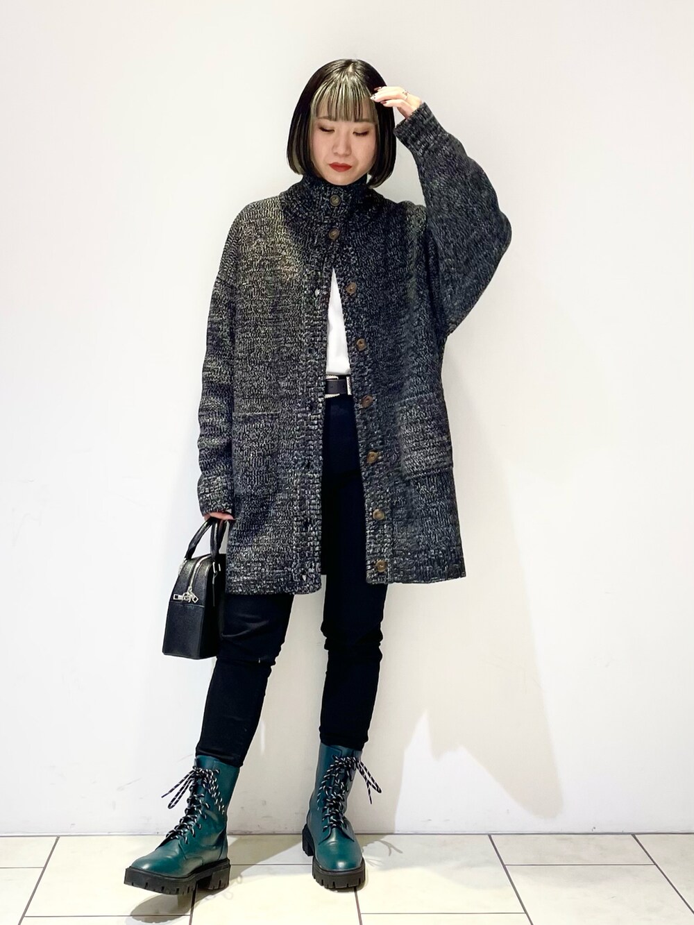 ブラック系のデニムパンツ、グリーン系のブーツ、ブラック系のショルダーバッグを着用したレディースの冬コーディネートの2枚目の写真