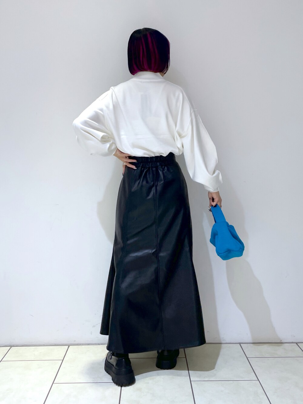 ホワイト系のニット/セーター、ブルー系のハンドバッグ、ブラック系のローファーを着用したレディースの秋コーディネートの4枚目の写真