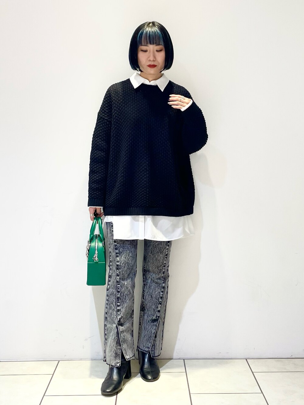 ホワイト系のシャツ/ブラウス、ブラック系のニット/セーター、グリーン系のショルダーバッグを着用したレディースの春コーディネートの2枚目の写真