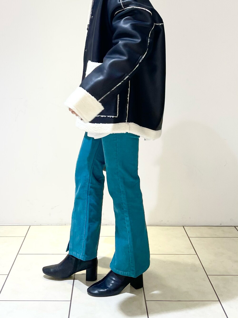 ブラック系のブルゾン、ベージュ系のニット/セーター、ホワイト系のTシャツ/カットソーを着用したレディースの冬コーディネートの5枚目の写真