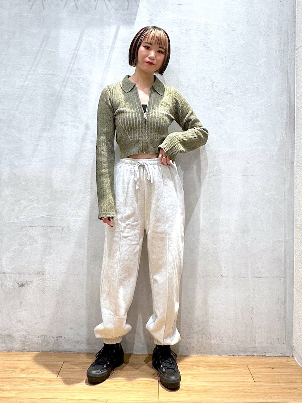 グレー系のスウェットパンツ、グリーン系のニット/セーターを着用したレディースの秋コーディネートの3枚目の写真