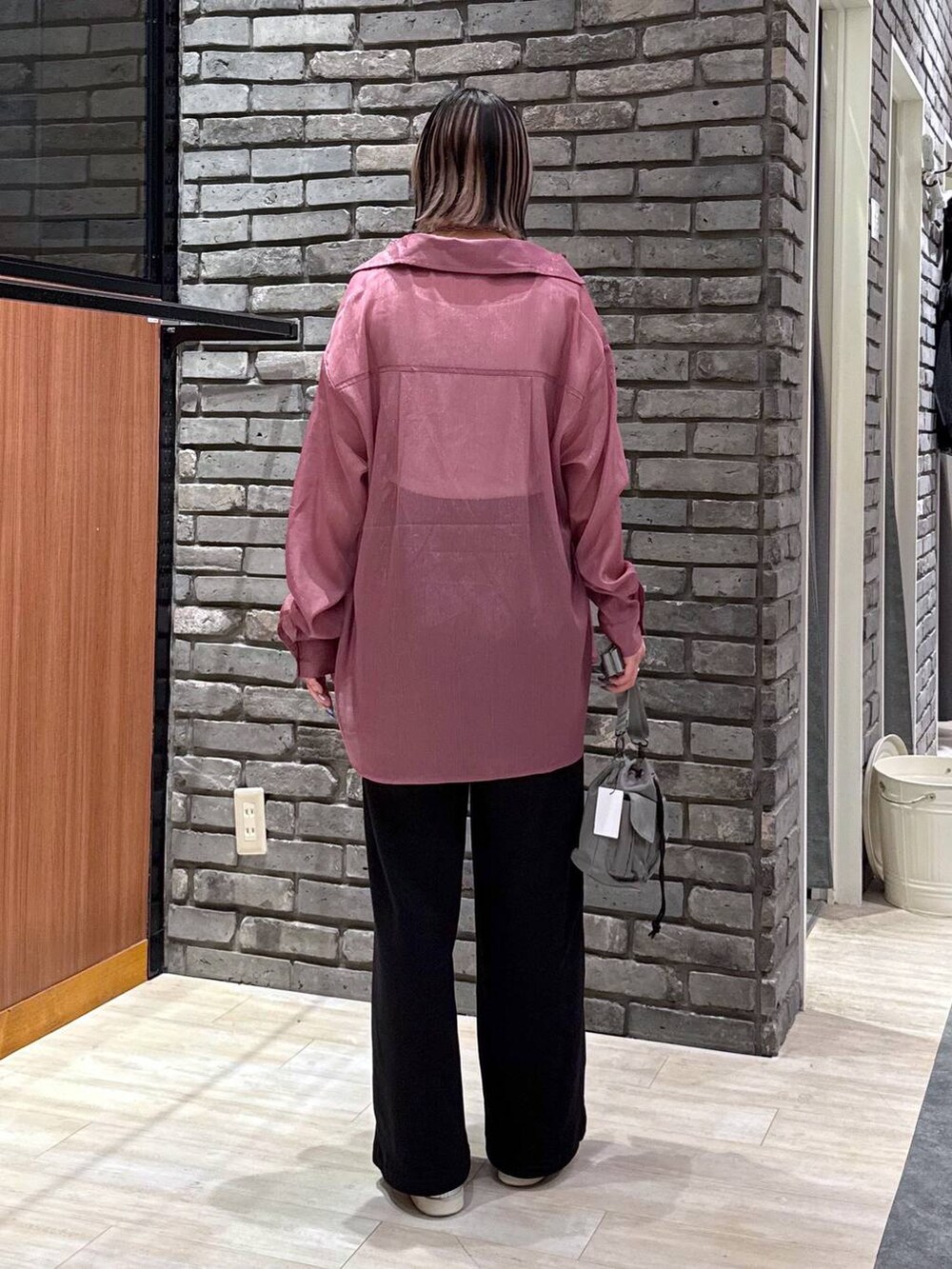 ベージュ系のショルダーバッグ、レッド系のシャツ/ブラウス、ブラック系のスウェットパンツを着用したレディースの春コーディネートの2枚目の写真