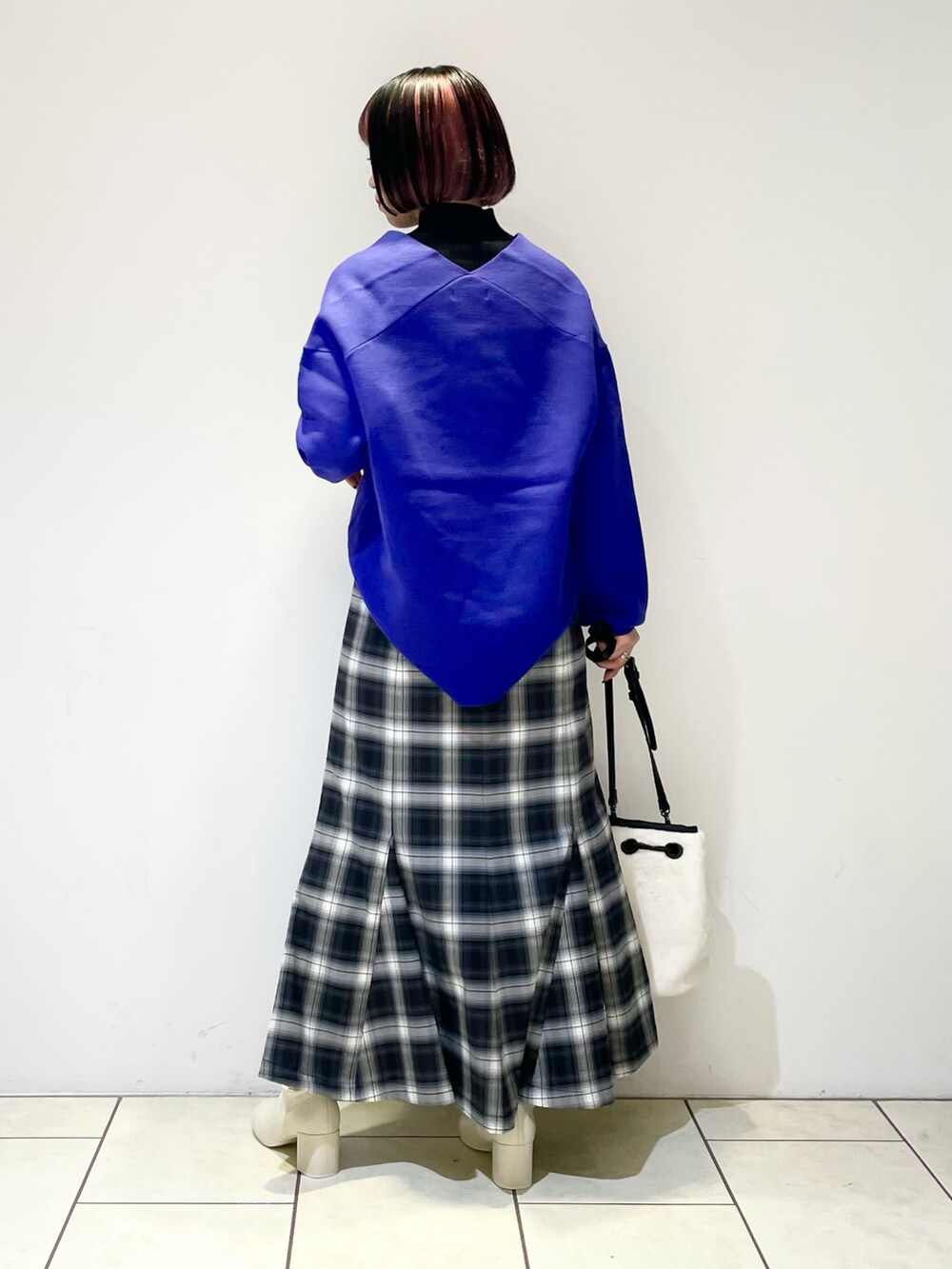 ブラック系のニット/セーター、ブルー系のニット/セーター、ブラック系のスカートを着用したレディースの冬コーディネートの3枚目の写真