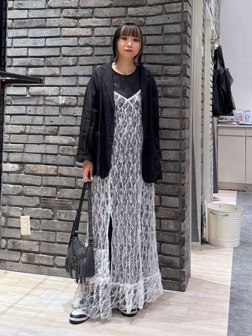 ブラック系のショルダーバッグ、グレー系のTシャツ/カットソー、ブラック系のテーラードジャケットを着用したレディースの春コーディネートの2枚目の写真