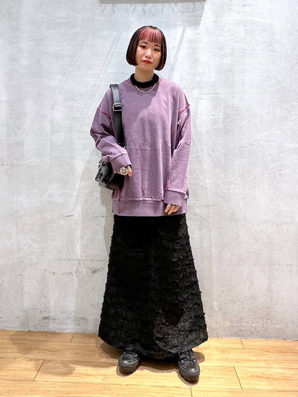 パープル系のスウェット、ブラック系のショルダーバッグ、ブラック系のワンピースを着用したレディースの秋コーディネートの3枚目の写真