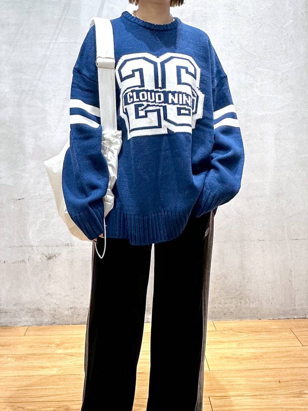 ホワイト系のショルダーバッグ、ブラック系のその他パンツ、ブルー系のニット/セーターを着用したレディースの秋コーディネートの6枚目の写真