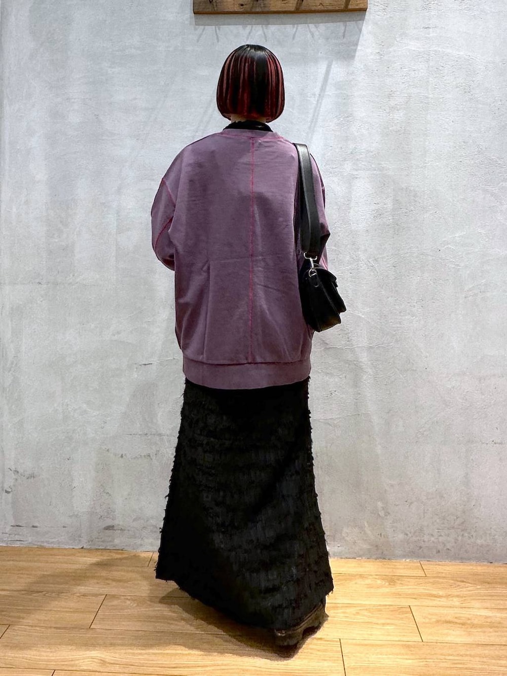 パープル系のスウェット、ブラック系のショルダーバッグ、ブラック系のワンピースを着用したレディースの秋コーディネートの4枚目の写真